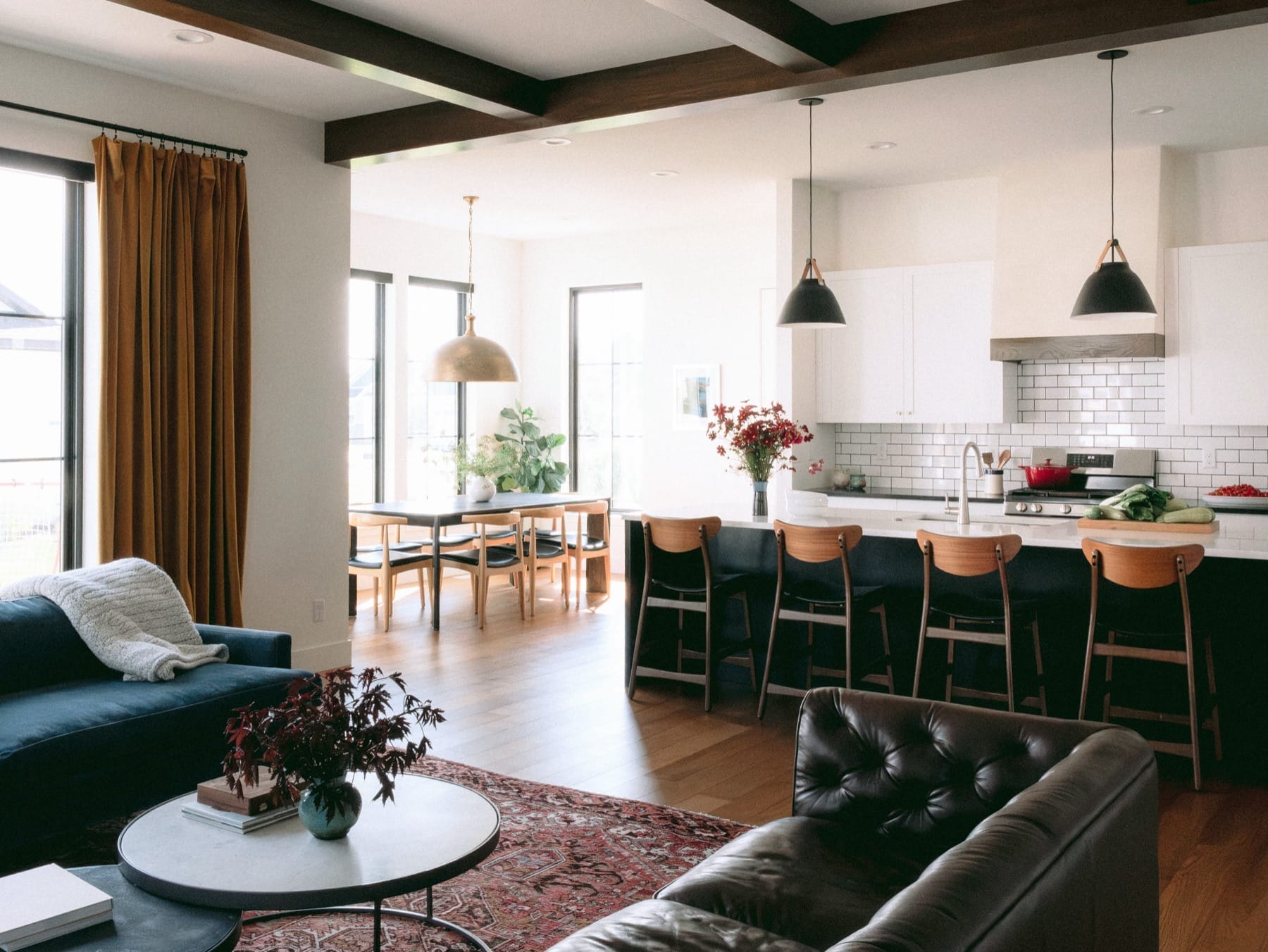 Open-plan kitchen and living area with a green island and leather sofa