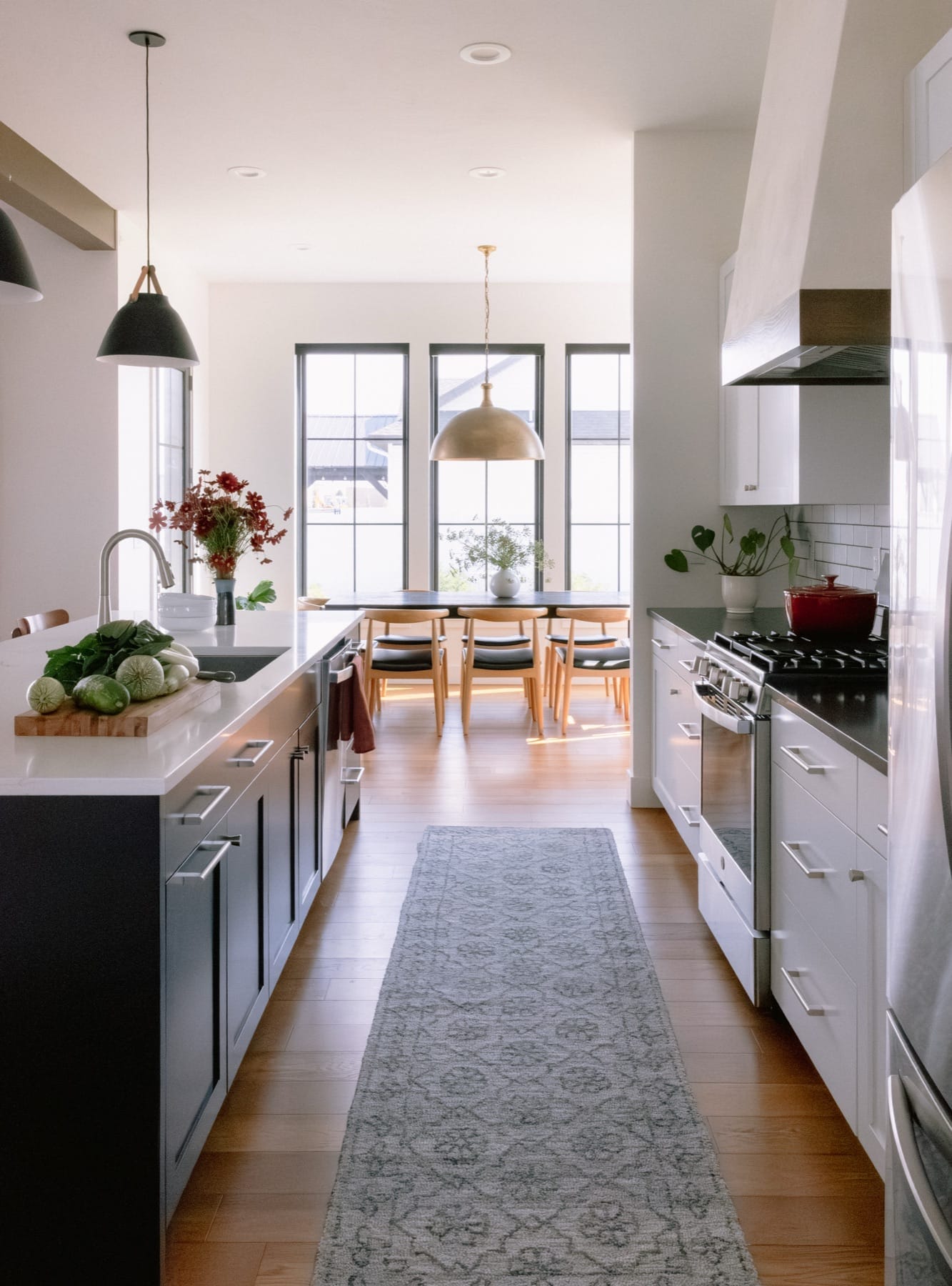 Galley kitchen with a runner rug opening to the dining area