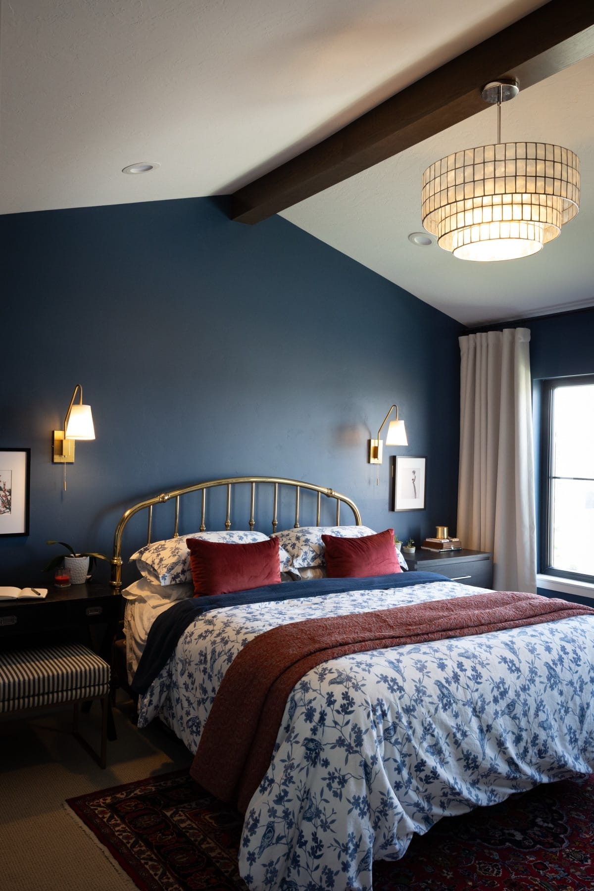 Primary bedroom with navy walls, a brass bed and floral bedding