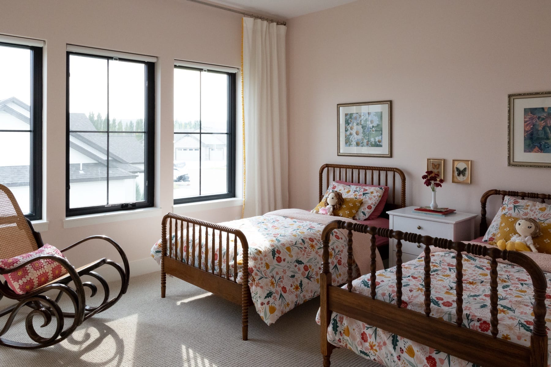 Child's bedroom with pink walls and two spindle beds