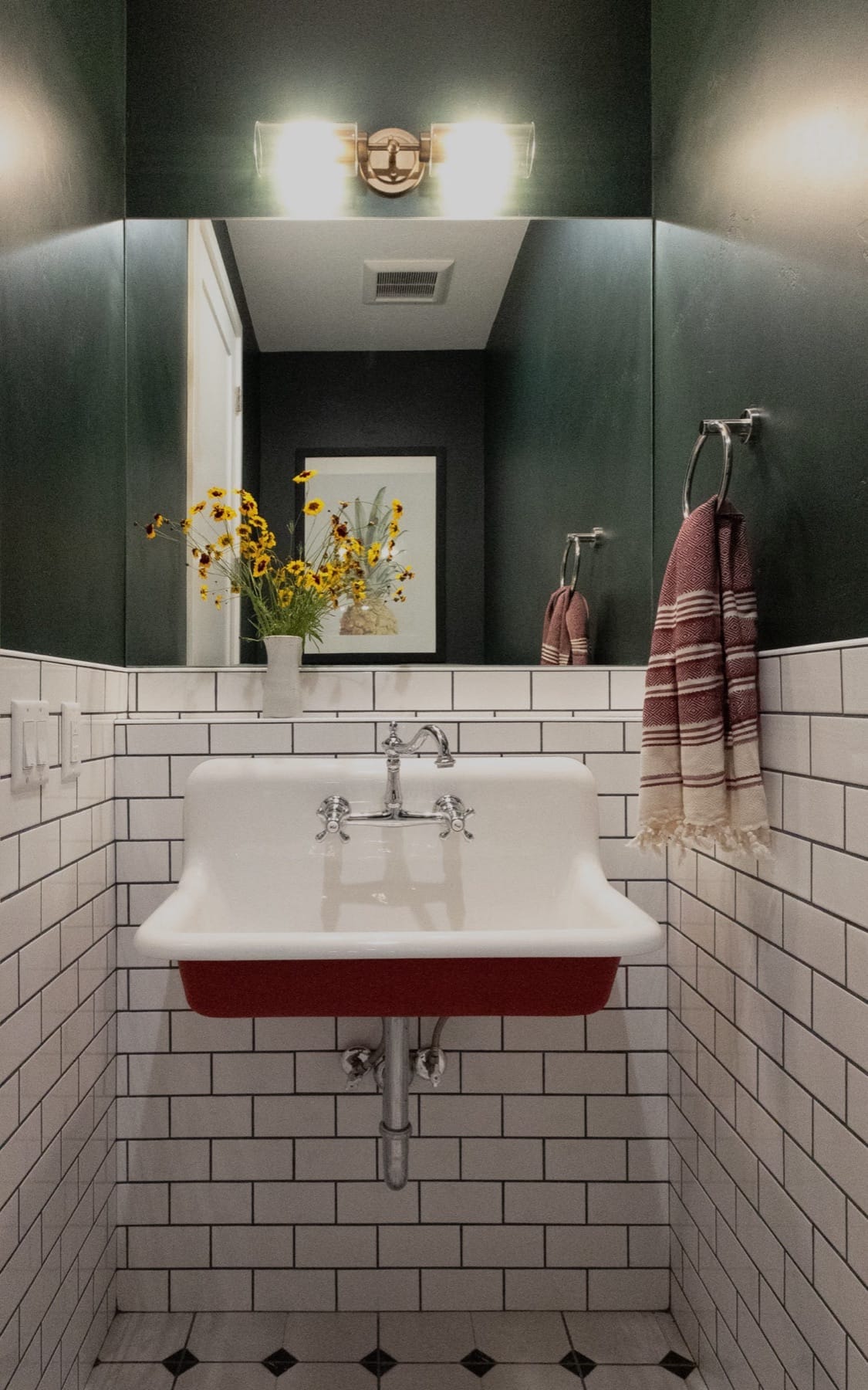 Powder room with a red wall-mount sink and white subway tile