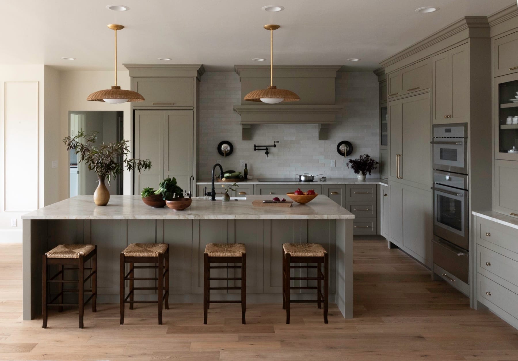Kitchen island with woven counter stools in a gray kitchen