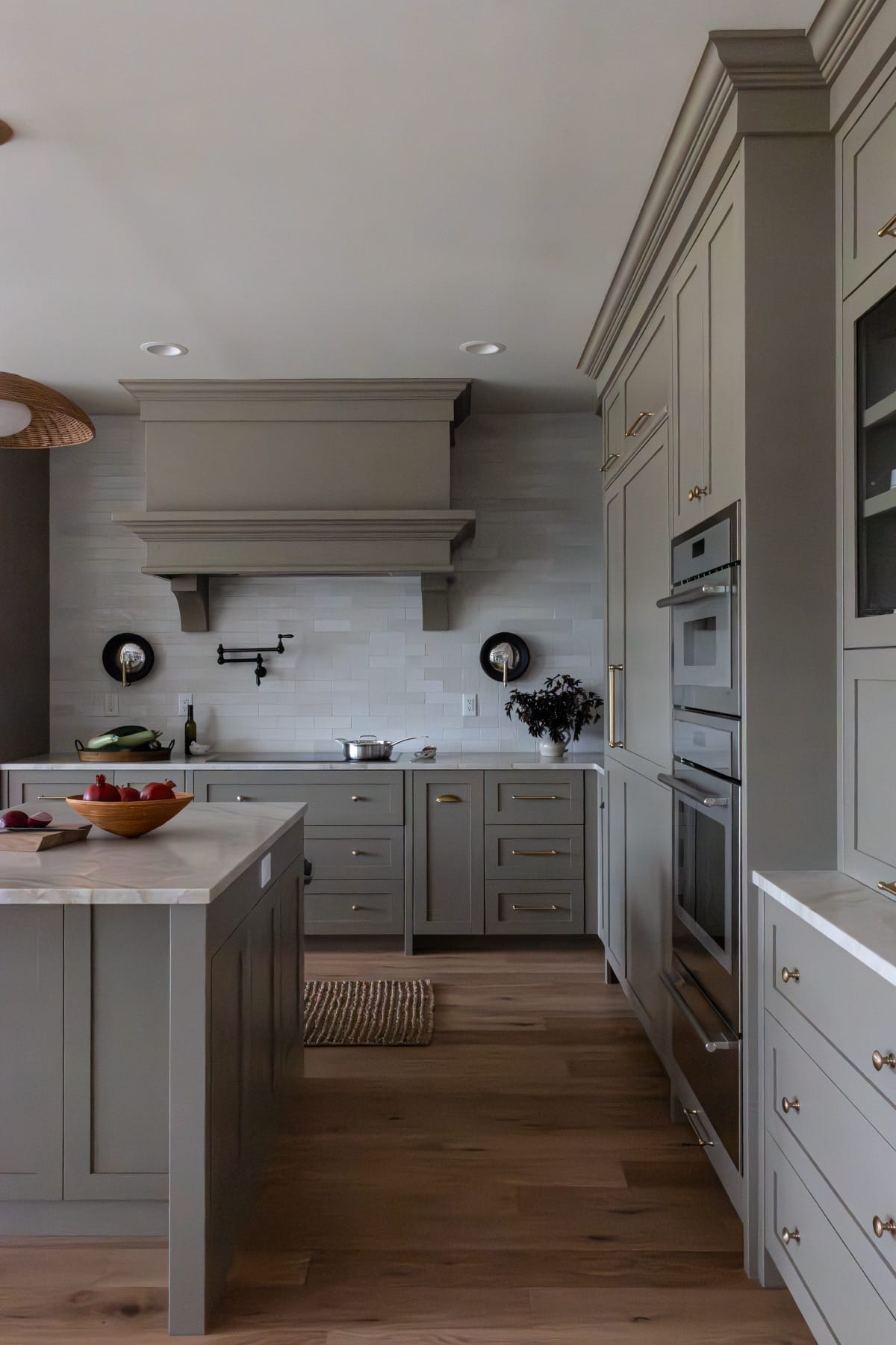 Kitchen range wall with a gray cabinet hood and tile backsplash