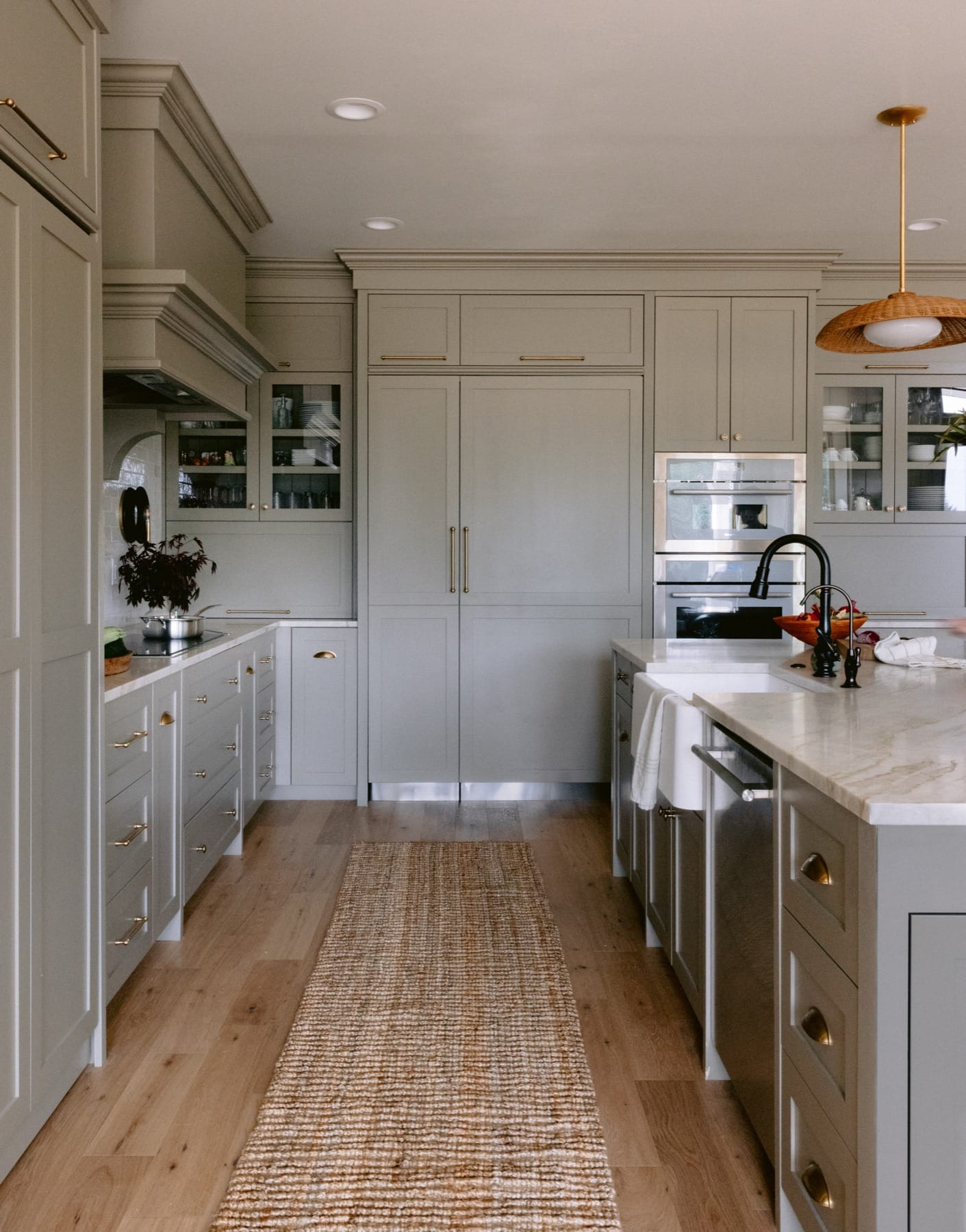 Kitchen with gray inset cabinetry, a runner rug and wood floors