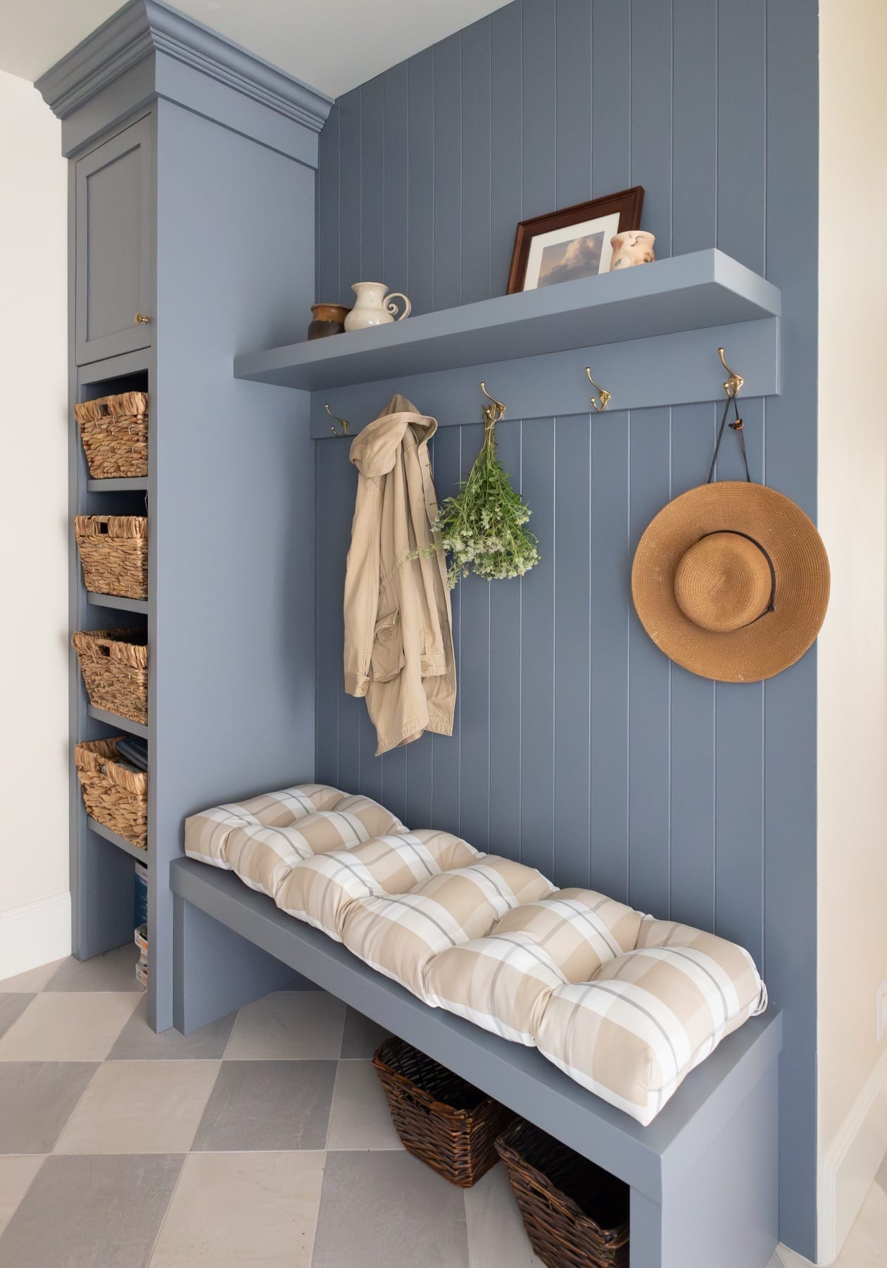 Mudroom bench with a plaid cushion and woven baskets