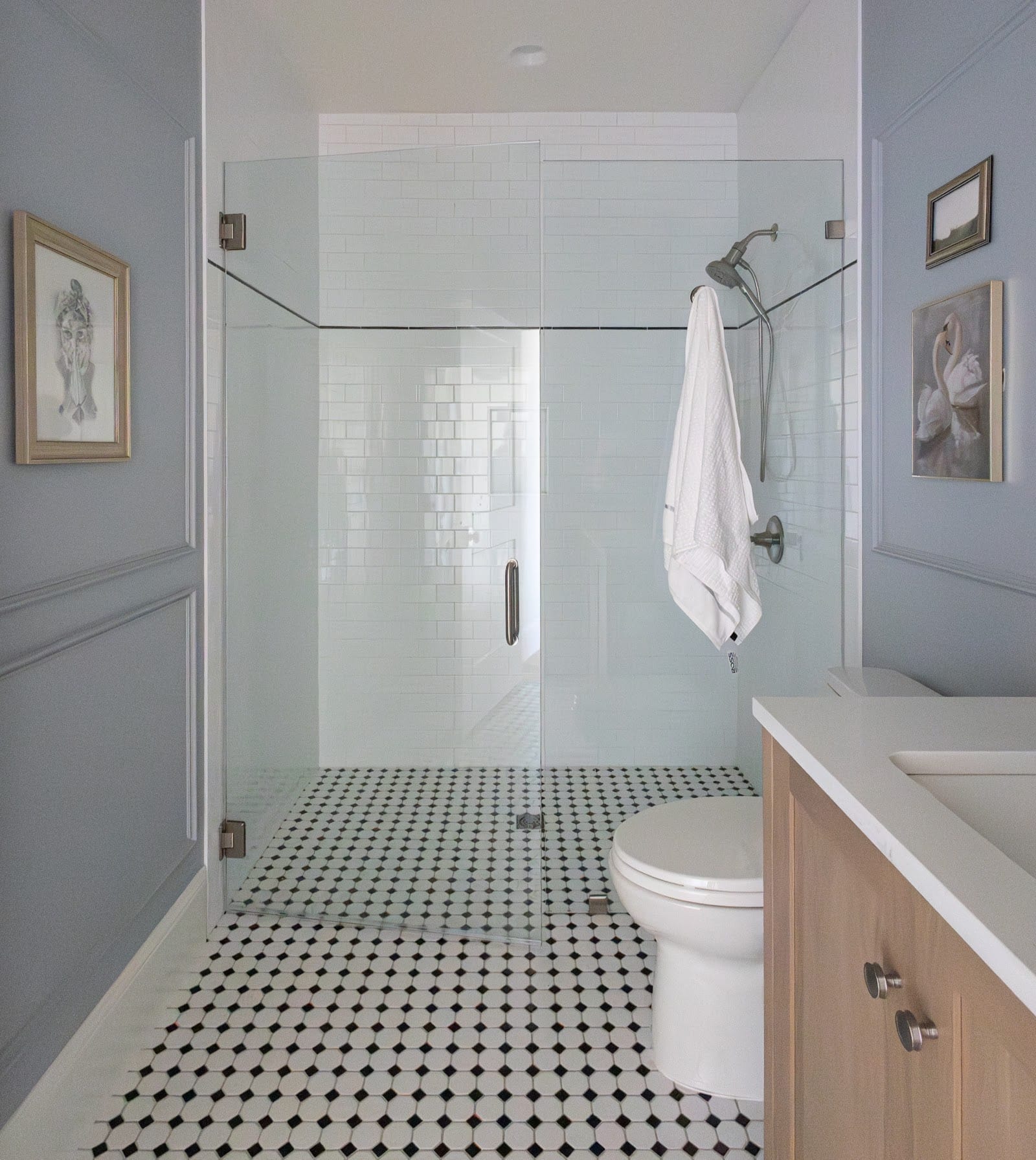 Guest bathroom with a glass shower and black-and-white hex tile floor