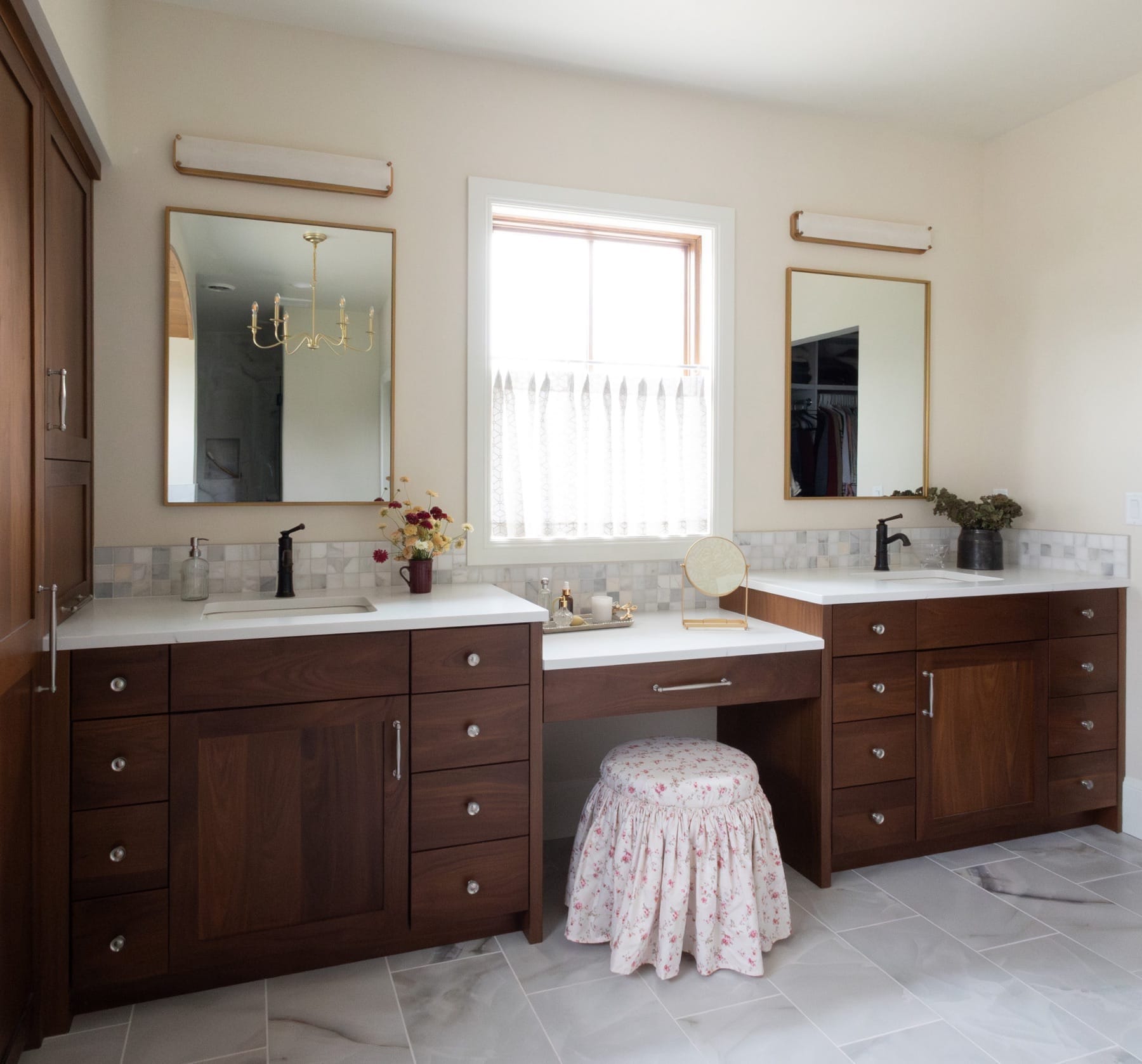 Primary bathroom with a walnut double vanity and makeup seat