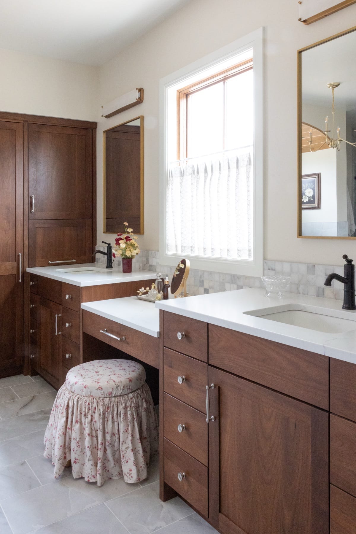 Primary bathroom vanity beside a window with a cafe curtain