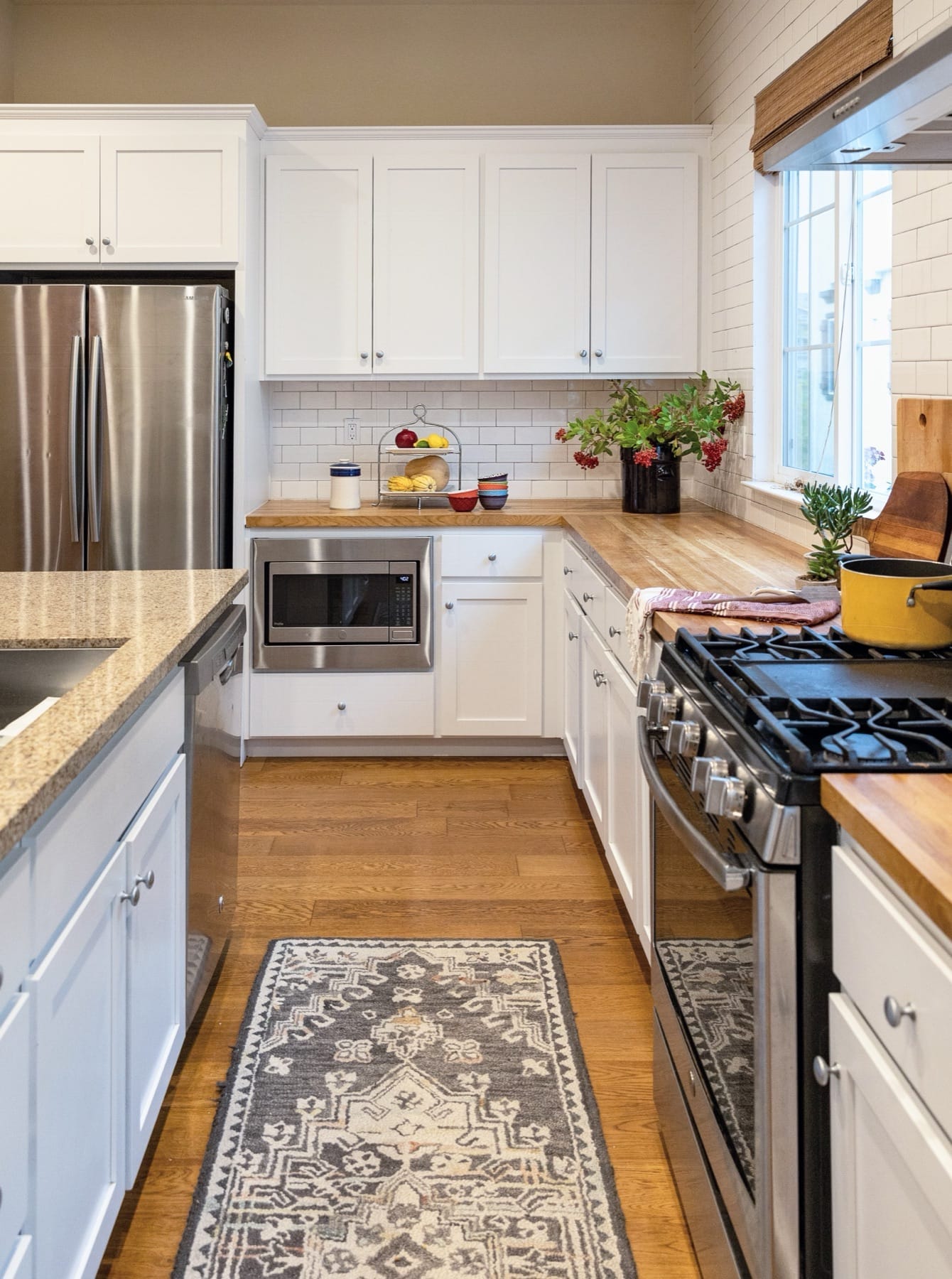 Townhouse kitchen with a gas range and a patterned runner rug
