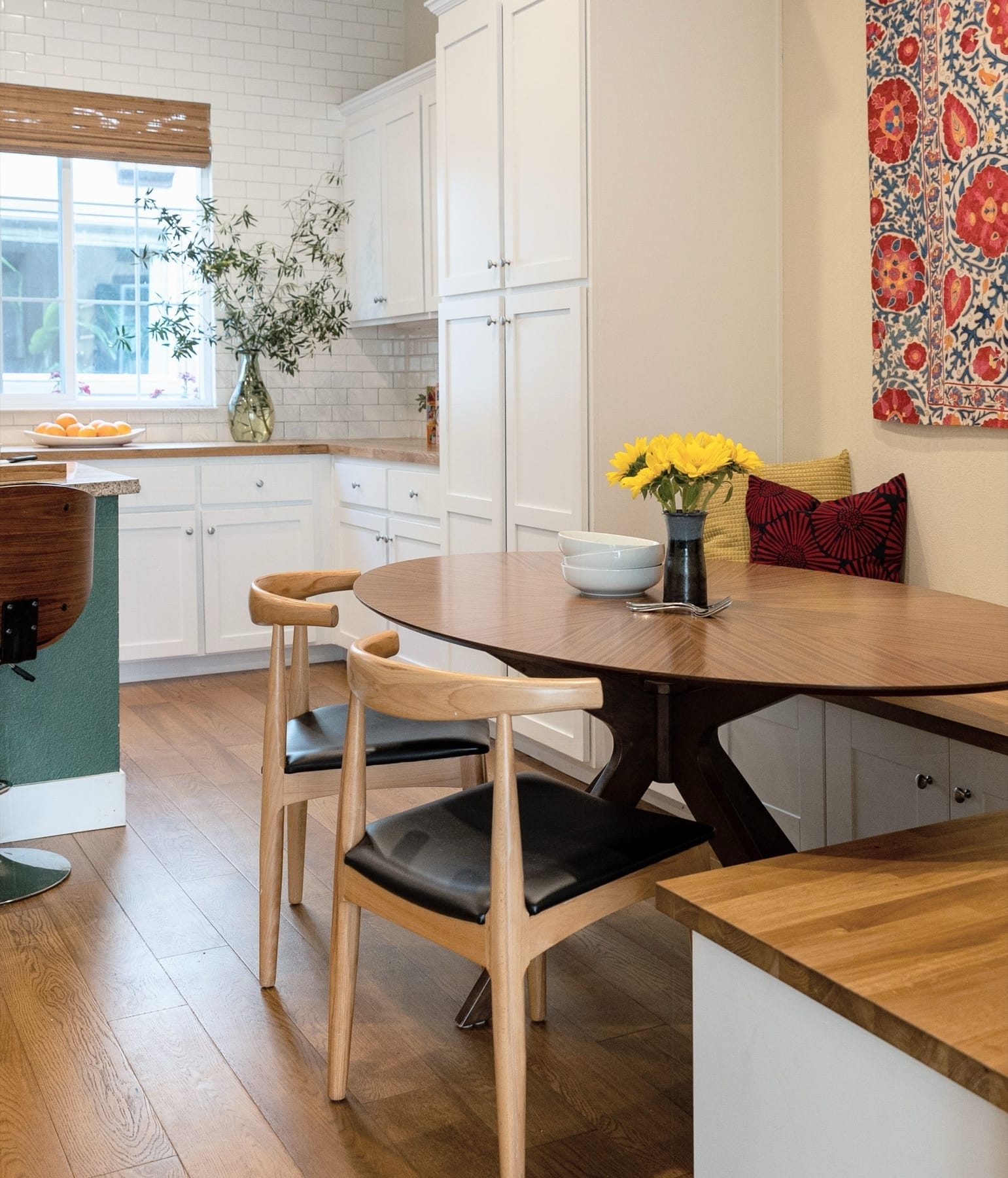Kitchen and breakfast table with a suzani textile wall hanging